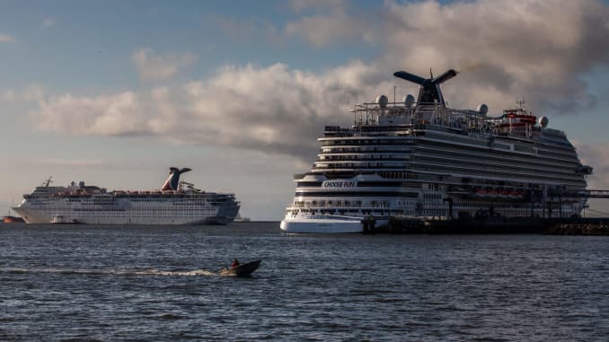 A man navigates his boat next to Cruise Ships docked at the port of Long Beach during the COVID-19 Coronavirus pandemic on April 11, 2020 in Long Beach, California.