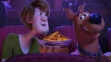 Shaggy and Scooby-Doo eat nachos in a movie theater in Warner Bros. "Scoob!"