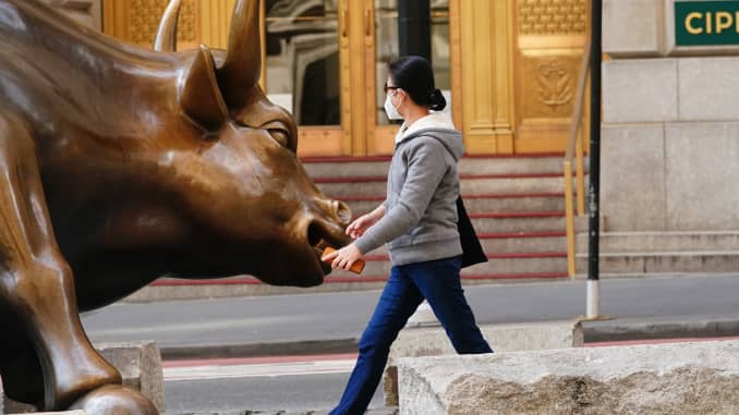 A view of the charging Bull with a woman in New York City USA during coronavirus pandemic on April 25, 2020.