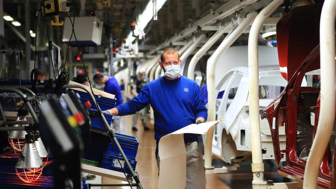 An automobile assembly line worker wears a protective face mask as Volkswagen AG (VW) restart production at their headquarter factory in Wolfsburg, Germany, on Monday, April 27, 2020. Volkswagen is restarting output at its Wolfsburg car plant, the worlds biggest, with a labor leaders warning that political fallout from the coronavirus pandemic could be more harmful than production disruptions.