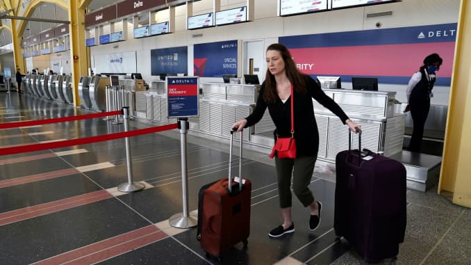 A lone passenger leaves a Delta Airlines counter after checking in for a flight at Reagan National airport as the outbreak of the novel coronavirus (COVID-19) pandemic continues to keep airline travel at minimal levels and the U.S. economy contracts in th