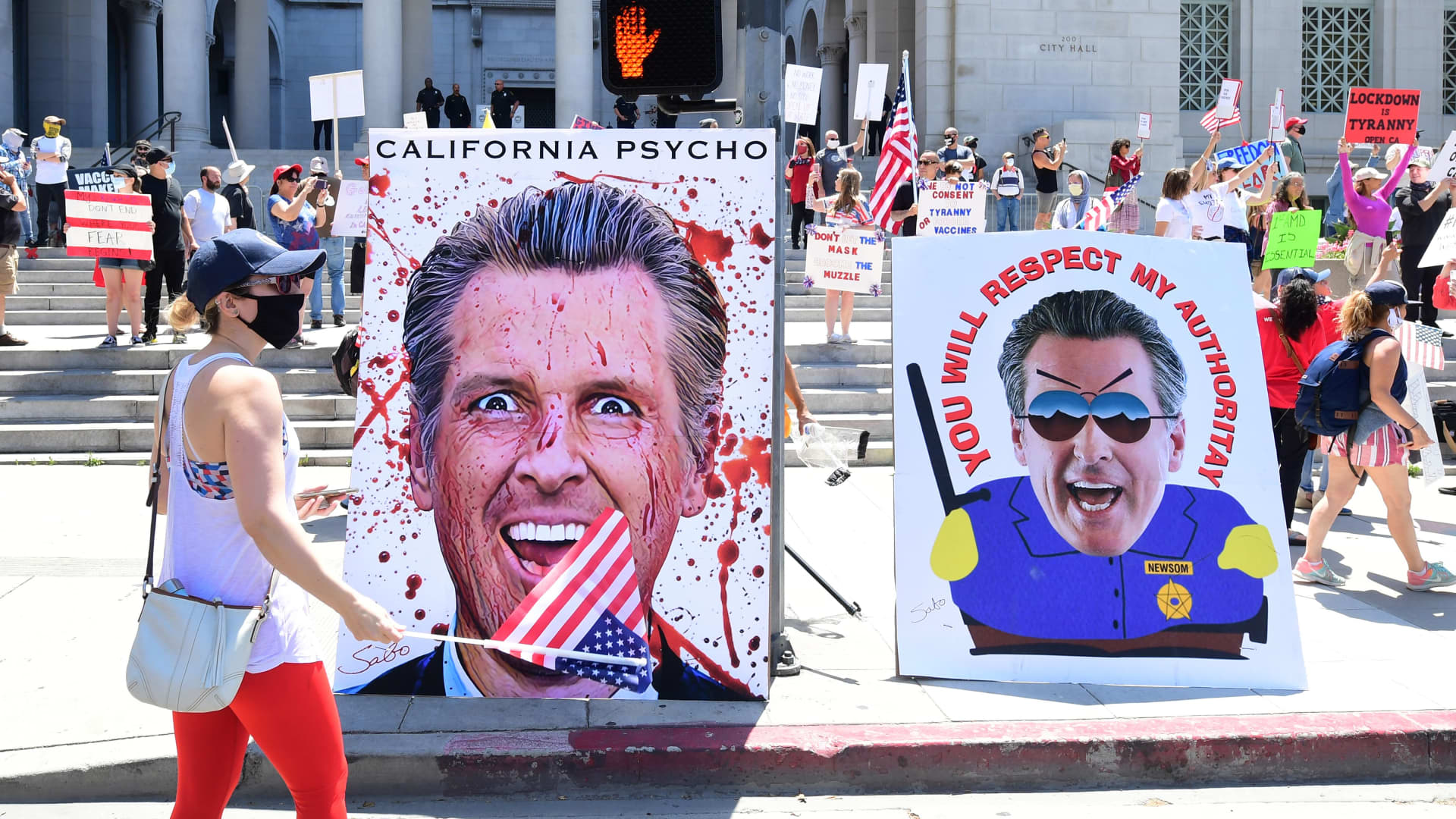 Demonstrators rally in front of posters with California Governor Gavin Newsom outside Los Angeles City Hall on May 1, 2020, to demand the end to the state's shutdown due to the coronavirus pandemic.