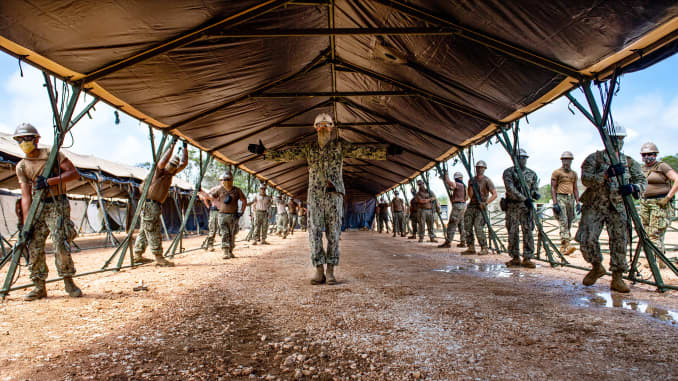 Sailors assigned to Task Force 75.5 prepare to lift a tent during construction of a 150-bed expeditionary medical facility at Naval Base Guam.