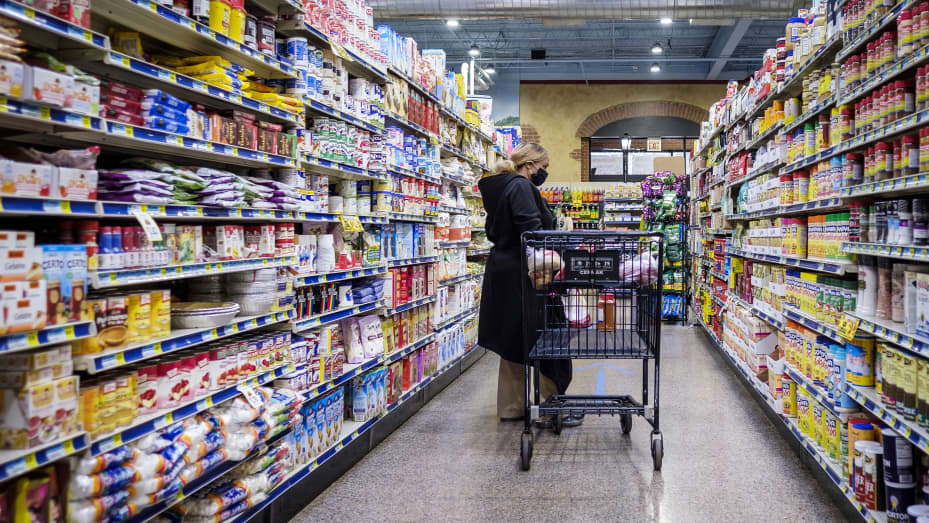 A shopper wearing a protective mask walks down an aisle at a grocery store in Chicago, Illinois, U.S., on Thursday, May 7, 2020.