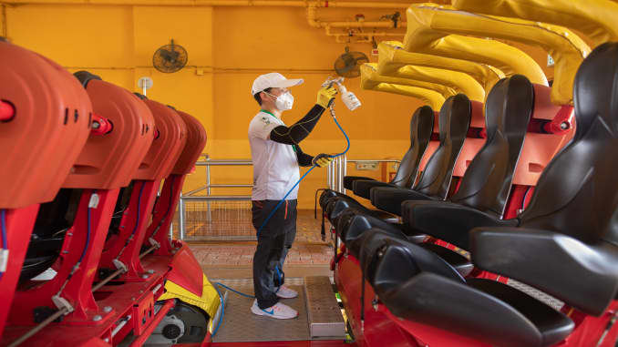 A worker wearing a protective mask sprays a nano-photocatalytic coat on a roller coaster train during a media tour at Ocean Park, temporarily closed due to the coronavirus, in Hong Kong, China, on Friday, May 8, 2020. The theme park has been temporarily closed since Jan. 26 due to the pandemic.