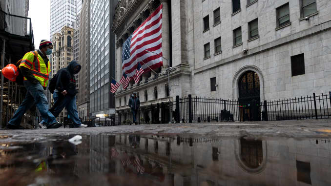 Two men wearing a masks walks pass the New York Stock Exchange (NYSE) on April 30, 2020 in New York City.