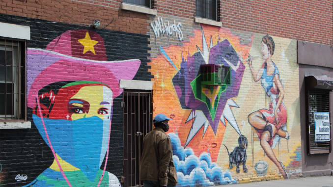 A man walks past a wall mural in the Mott Haven neighborhood of the Bronx. May, 14 2020.