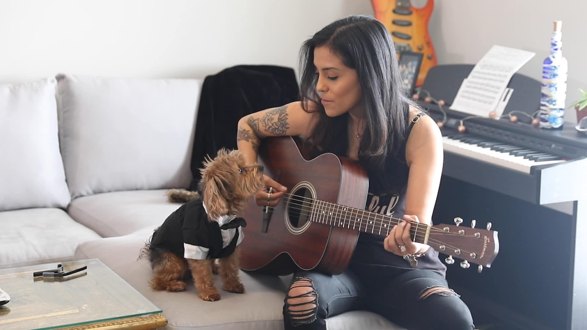 Andrea Contreras plays guitar with her dog, Kuzco, in her apartment.