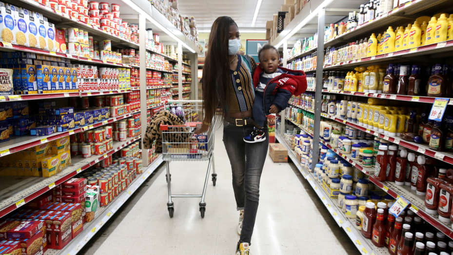 Mic'Kale Smith, who works as a security guard but has had to take time off to care for her son during the coronavirus disease (COVID-19) outbreak, wears a face mask as she shops with her son Da'Mier at the Tiger Market in Oxon Hill, Maryland, U.S. May 20,