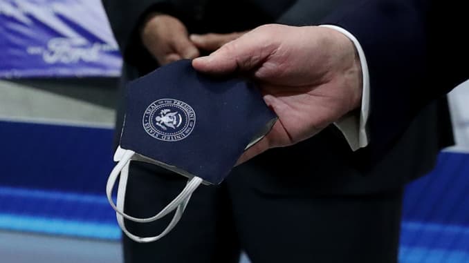 U.S. President Donald Trump holds a protective face mask with a presidential seal on it that he said he had been wearing earlier in his tour at the Ford Rawsonville Components Plant that is manufacturing ventilators, masks and other medical supplies durin