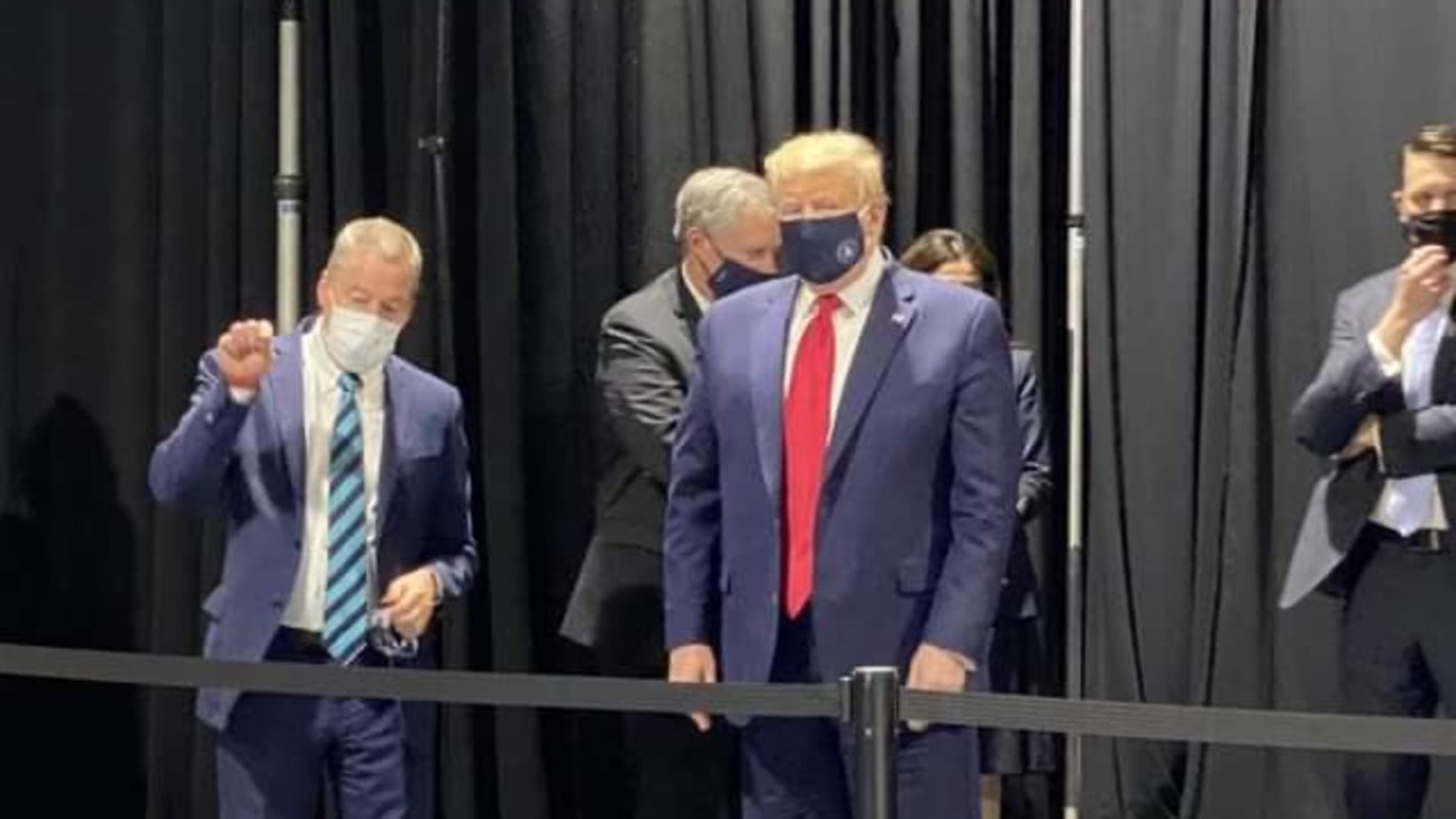 President Donald Trump wears a mask during a private viewing of three Ford GTs from over the years at the Ford Rawsonville plant.