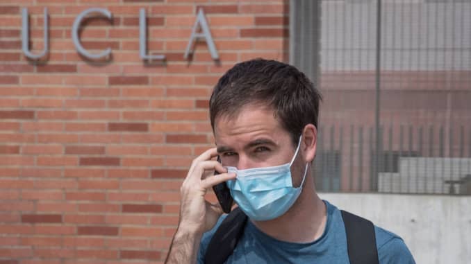A man wears a face mask to protect against the COVID-19 (Coronavirus) as he leaves UCLA in Westwood, California.