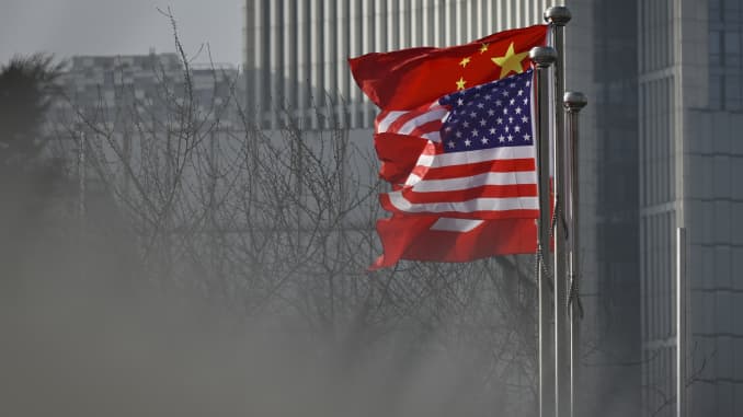 Las banderas nacionales chinas y estadounidenses ondean en la entrada de un edificio de oficinas de la compañía en Beijing.