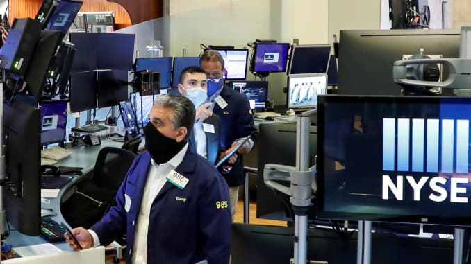 Traders wearing masks work inside posts, on the first day of in-person trading since the closure during the outbreak of the coronavirus disease (COVID-19) on the floor at the New York Stock Exchange (NYSE) in New York, U.S., May 26, 2020.