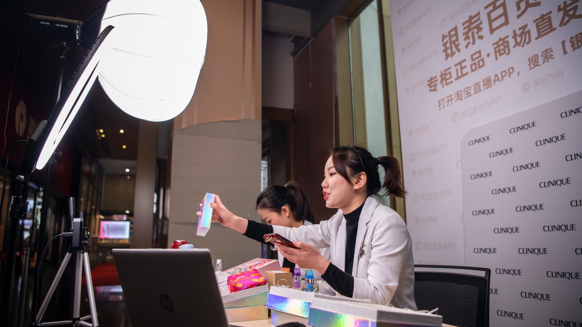Sales associates at one of Alibaba-owned InTime's store display products for sale during a livestream.