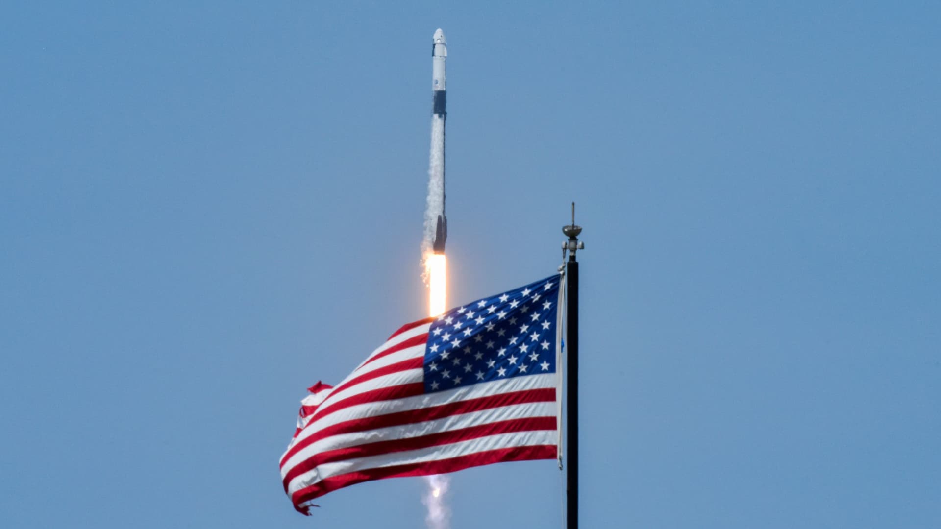 An American flag is seen as SpaceX Falcon 9 rocket and Crew Dragon spacecraft carrying NASA astronauts Douglas Hurley and Robert Behnken lifts off during NASA's SpaceX Demo-2 mission to the International Space Station from NASA's Kennedy Space Center in Cape Canaveral, Florida, U.S. May 30, 2020.