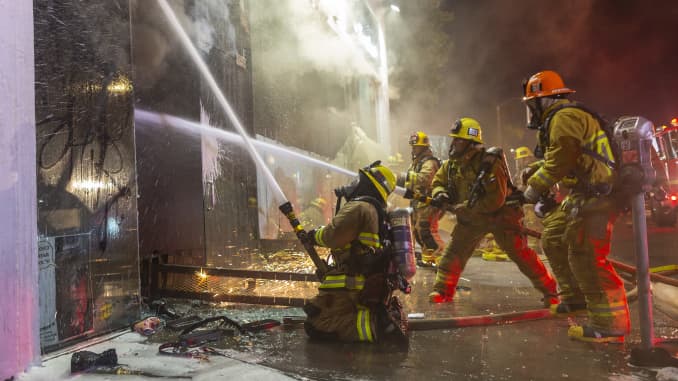 Los bomberos combaten el incendio de una estructura en Melrose Avenue en el distrito de Fairfax durante las manifestaciones tras la muerte de George Floyd el 30 de mayo de 2020 en Los Ángeles, California.