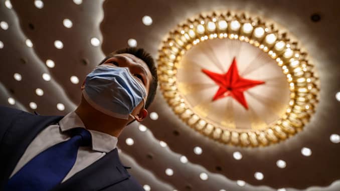 A Chinese security officer wears a protective mask at the end of the closing session of the National People's Congress at the Great Hall of the People on May 28, 2020 in Beijing, China.