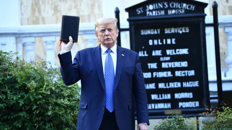 US President Donald Trump holds up a bible in front of St John's Episcopal church after walking across Lafayette Park from the White House in Washington, DC on June 1, 2020.