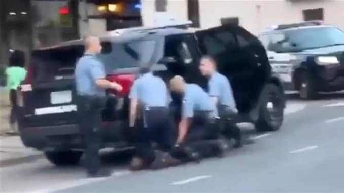A screen grab of video obtained by NBC News appears to show three officers kneeling on the ground near Floyd, while another stands nearby.