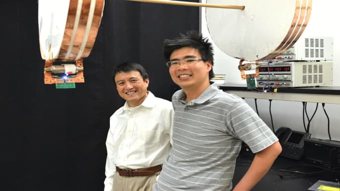 Los investigadores de Stanford Sid Assawaworrarit (derecha) se encuentran con su colaborador, el profesor Shanhui Fan, frente a dos bobinas magnéticas que pueden transmitir de forma inalámbrica 10 W de potencia a cualquier distancia de hasta 2 pies, incluso mientras se mueven.