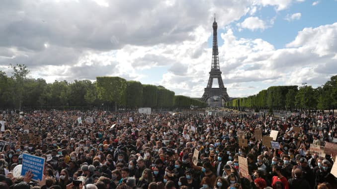 Mọi người tập trung tại Champ de Mars trước tháp Eiffel, tại Paris vào ngày 6 tháng 6 năm 2020, như một phần của cuộc biểu tình trên toàn thế giới 'Black Lives Matter' chống lại nạn phân biệt chủng tộc và sự tàn bạo của cảnh sát sau cái chết của George Floyd, một người đàn ông da đen không vũ trang bị giết trong khi bắt