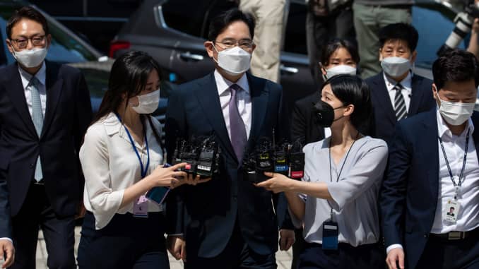 Jay Y. Lee, co-vice chairman of Samsung Electronics, center, wears a protective mask as he is surrounded by members of the media while arriving at the Seoul Central District Court in Seoul, South Korea, on Monday, June 8, 2020.
