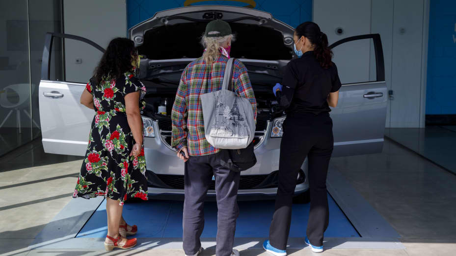 Customers inspect a Fiat Chrysler Automobiles NC Dodge Grand Caravan minivan at a Carvana Co. location in Westminster, California, U.S., on Thursday, May 28, 2020.