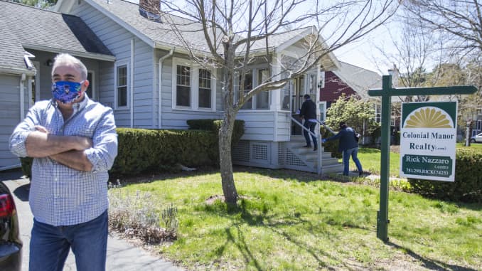 Rick Nazarro of Colonial Manor Realty waits in the driveway as a couple enters a property he is trying to sell on May 2, 2020 in Revere, Massachuetts.
