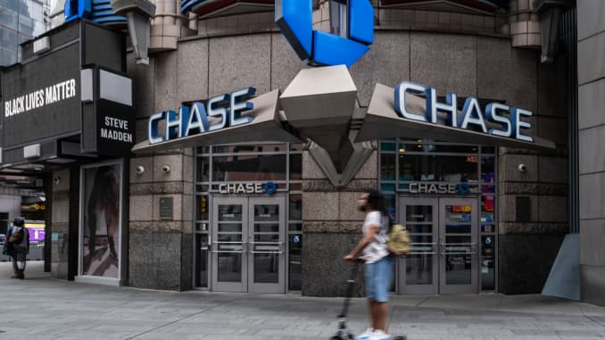 A person on a scooter rides past a JPMorgan Chase & Co. bank branch in New York, U.S., on Thursday, June 11, 2020.