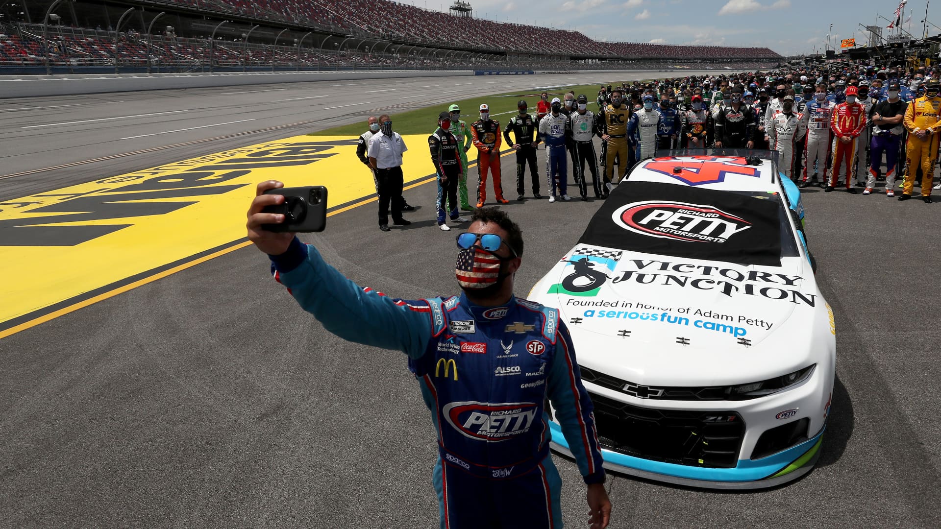 Bubba Wallace, driver of the #43 Victory Junction Chevrolet, takes a selfie with NASCAR drivers that pushed him to the front of the grid as a sign of solidarity with the driver prior to the NASCAR Cup Series GEICO 500 at Talladega Superspeedway on June 22, 2020 in Talladega, Alabama.