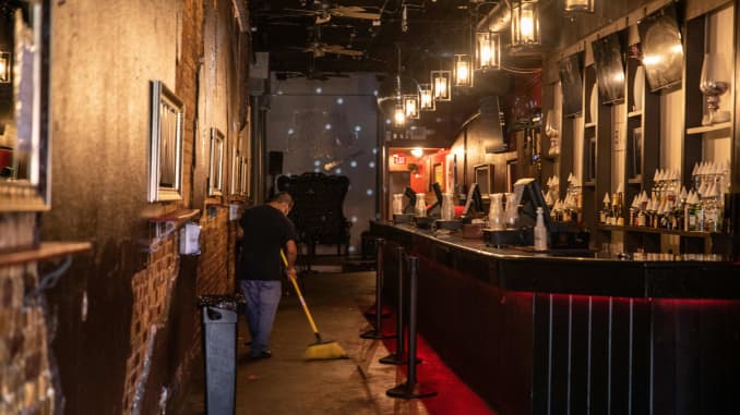 An employee sweeps inside a closed bar in Austin, Texas, June 26, 2020.