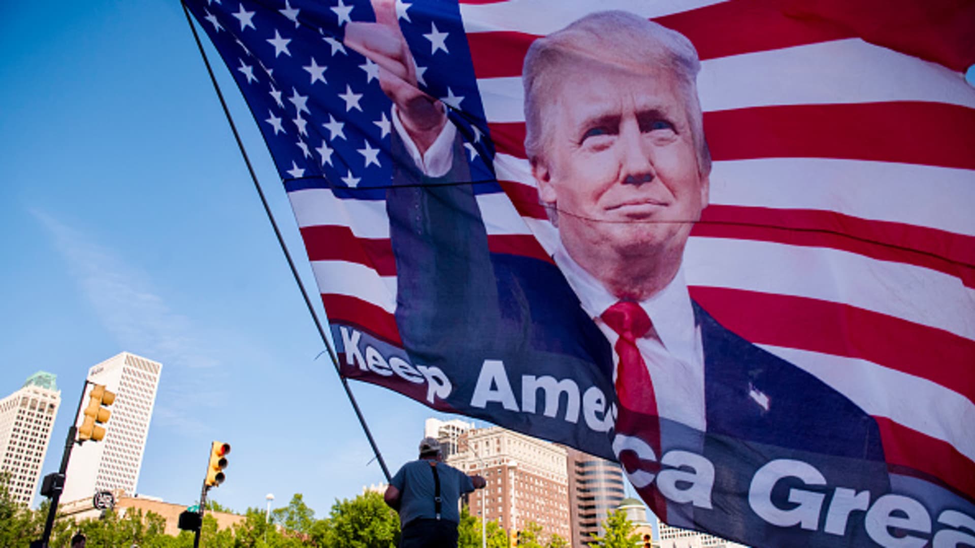 Randal Thom, 60, of Minnesota, waves an oversized flag of U.S. President Donald Trump outside the BOK Center in Tulsa, Oklahoma, on Thursday, June 18, 2020.
