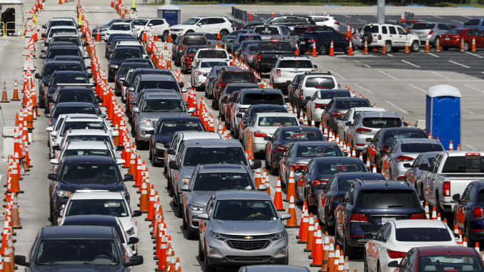 People sit in their vehicles while waiting in line to enter a Covid-19 drive-thru testing site at Hard Rock Stadium in Miami Gardens, Florida, U.S., on Tuesday, June 30, 2020.