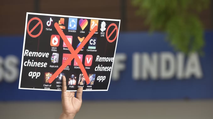A person holds up a poster calling for the boycott of Chinese mobile apps during a protest on June 30, 2020 in New Delhi, India.