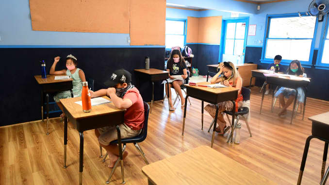 Children in an elementary school class wear masks and sit as desks spaced apart as per coronavirus guidelines during summer school sessions at Happy Day School in Monterey Park, California on July 9.