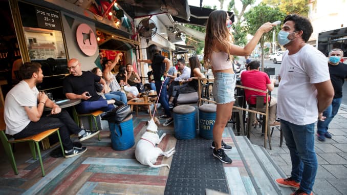 A customer has his temperature taken at the entrance to a restaurant as some businesses reopened at the end of last month under a host of new rules, following weeks of shutdown amid the coronavirus disease (COVID-19) crisis, in Tel Aviv, Israel, June 4, 2