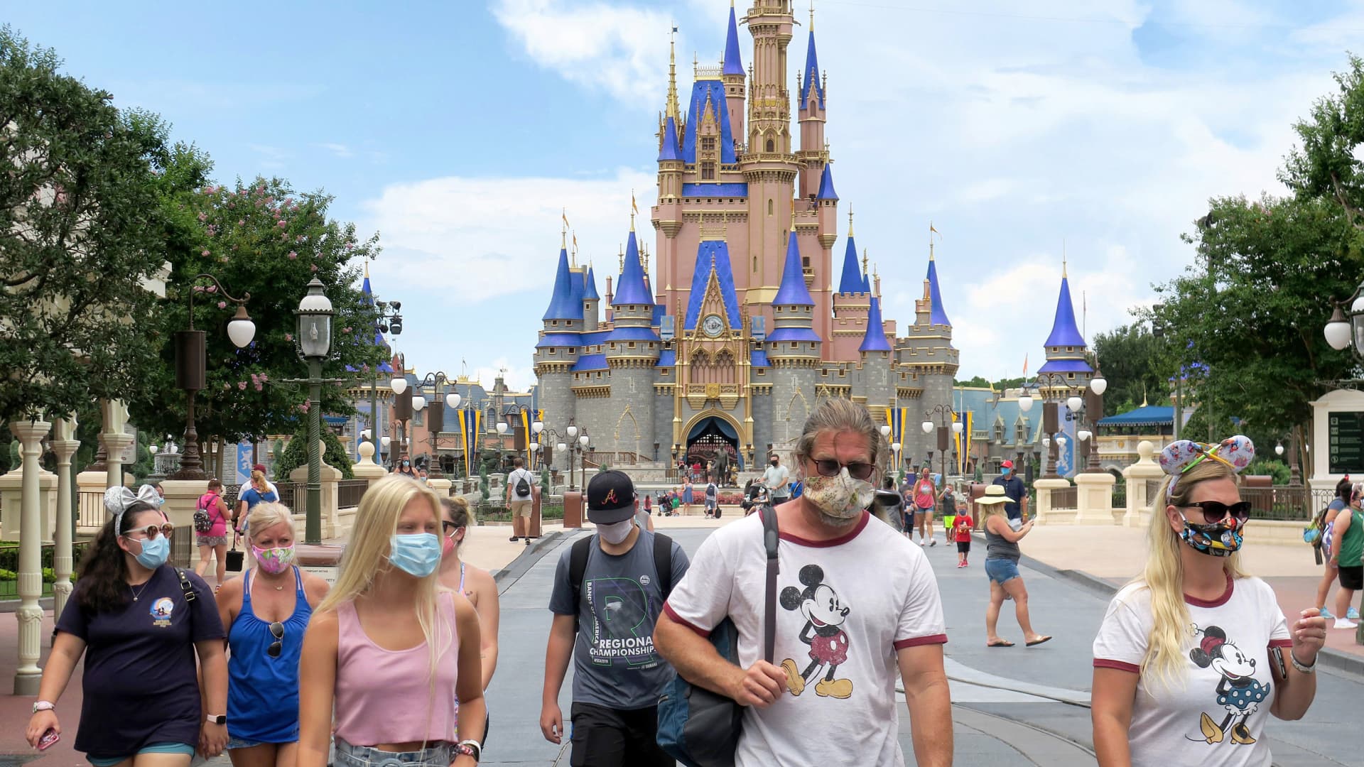 Guests wear masks. as required. to attend the official re-opening day of the Magic Kingdom at Walt Disney World in Lake Buena Vista, Florida, on Saturday, July 11, 2020.