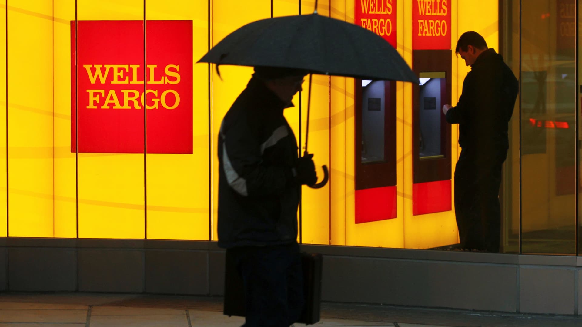 A man walks past a Wells Fargo Bank branch on a rainy morning in Washington.