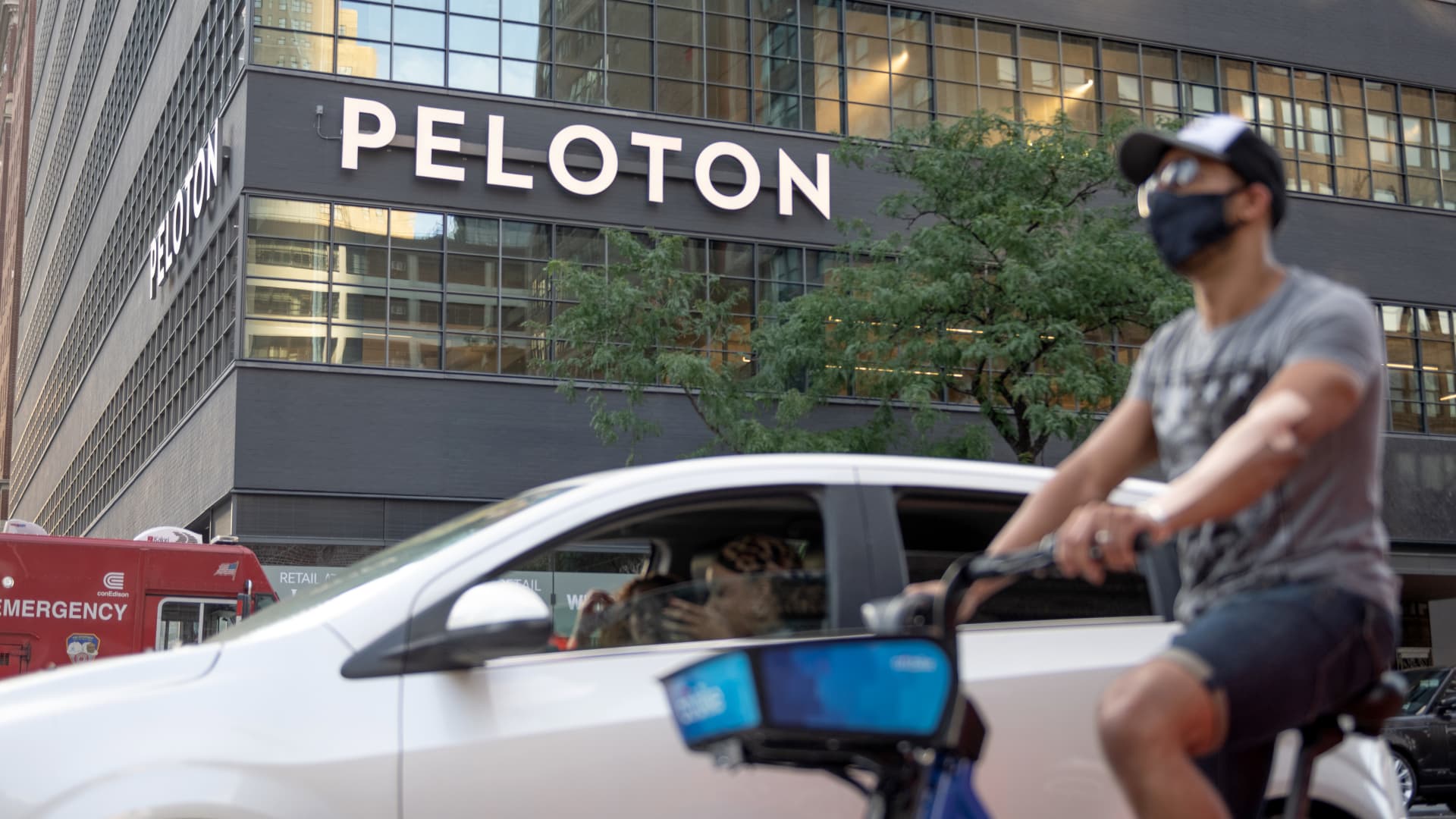 A Peloton office sign is seen near a person riding a bicycle as the city moves into Phase 3 of re-opening following restrictions imposed to curb the coronavirus pandemic on July 16, 2020 in New York City.