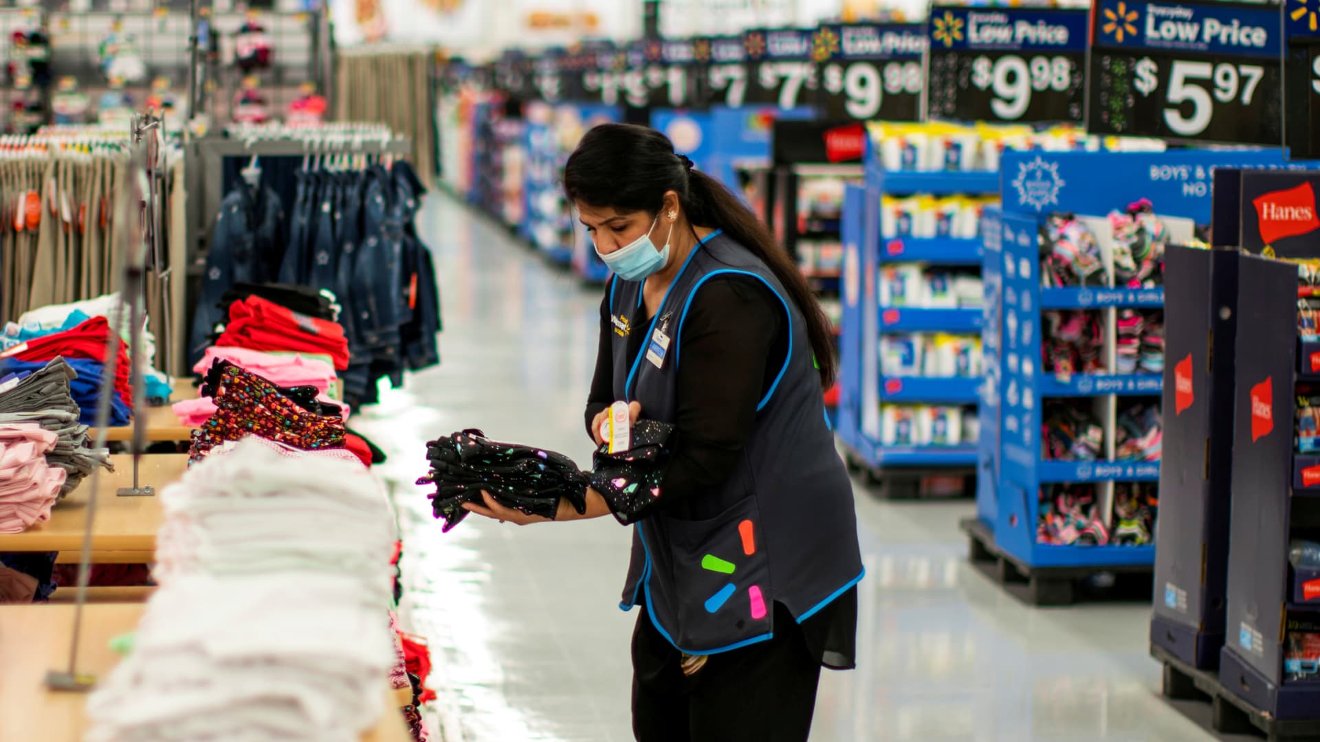 A worker is seen wearing a mask while organizing merchandise at a Walmart store, in North Brunswick, New Jersey, July 20, 2020.
