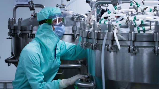 Một kỹ thuật viên phòng thí nghiệm dành riêng cho công thức vắc xin, đeo Thiết bị Bảo vệ Cá nhân (PPE), chuẩn bị các thùng thép không gỉ để sản xuất các chế phẩm vắc xin trước giai đoạn làm đầy ống tiêm, tại một công ty dược phẩm thế giới của Pháp Sanofi