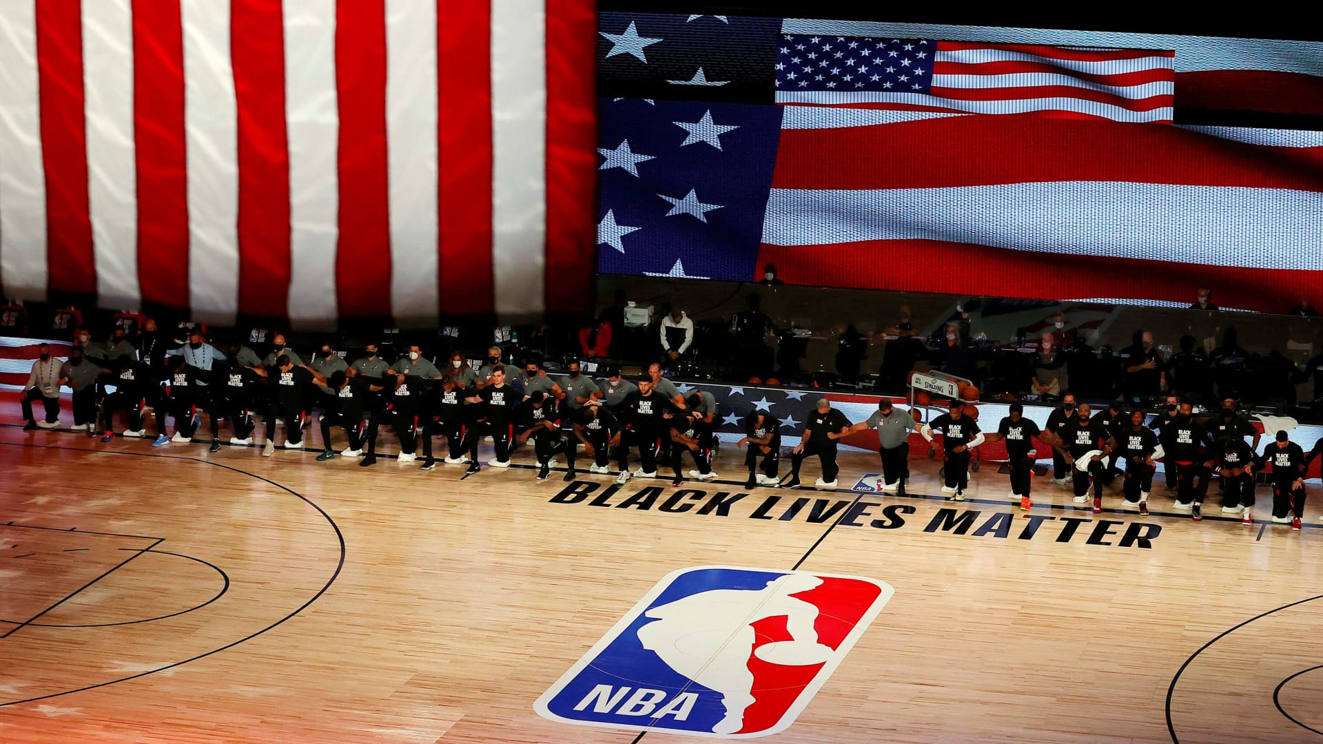 Players, coaches and staff kneel during the national anthem before the game between the Houston Rockets and the Portland Trail Blazers at The Arena at ESPN Wide World Of Sports Complex on August 04, 2020 in Lake Buena Vista, Florida.