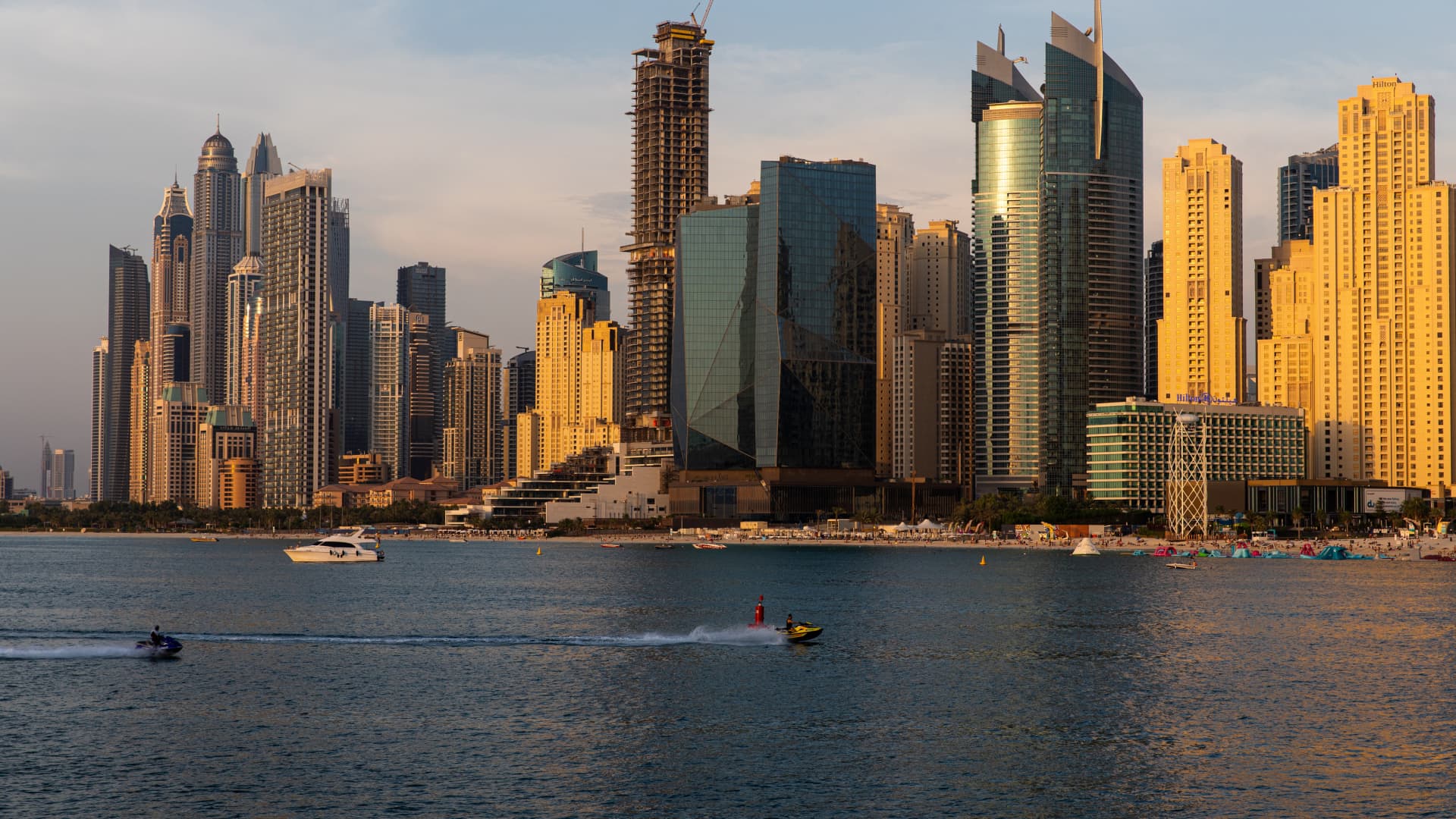 Jet skis pass by residential skyscrapers on the waterside in the Dubai Marina district in Dubai, United Arab Emirates, on Monday, June 8, 2020.