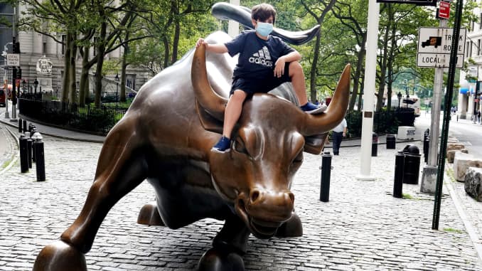 Un niño con una mascarilla se sienta en la estatua Charging Bull, también conocida como Wall Street Bull, luego del brote de la enfermedad por coronavirus (COVID-19) en Nueva York, el 19 de agosto de 2020.
