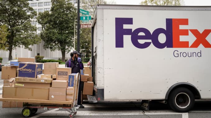 A FedEx worker unloads packages from his delivery truck on March 31, 2020 in Washington, DC.