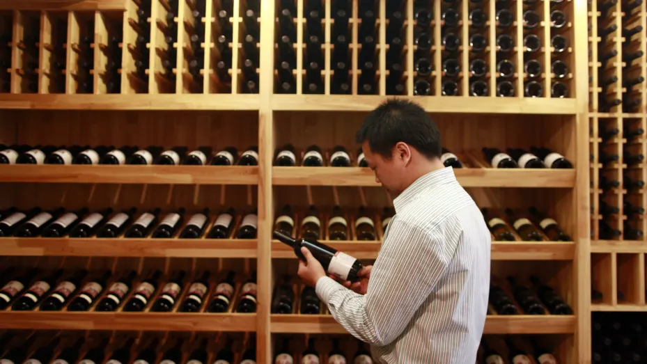 Lin Tiangui, representante de Winston Wine, observa una botella de vino producida en la propia bodega australiana de Winston Wine en una de sus tiendas en Shanghái, China, el 18 de octubre de 2011.