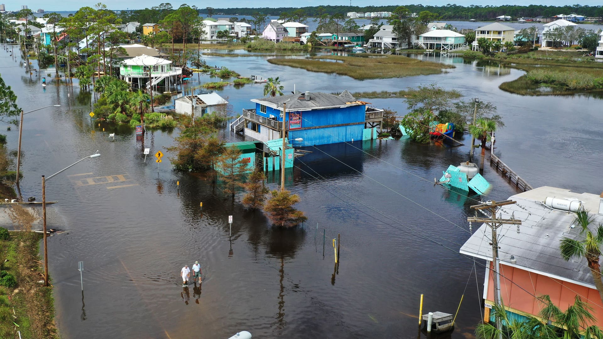 An aerial view from a drone shows people walking through a flooded street after Hurricane Sally passed through the area on September 17, 2020 in Gulf Shores, Alabama. The storm came ashore with heavy rain and high winds.