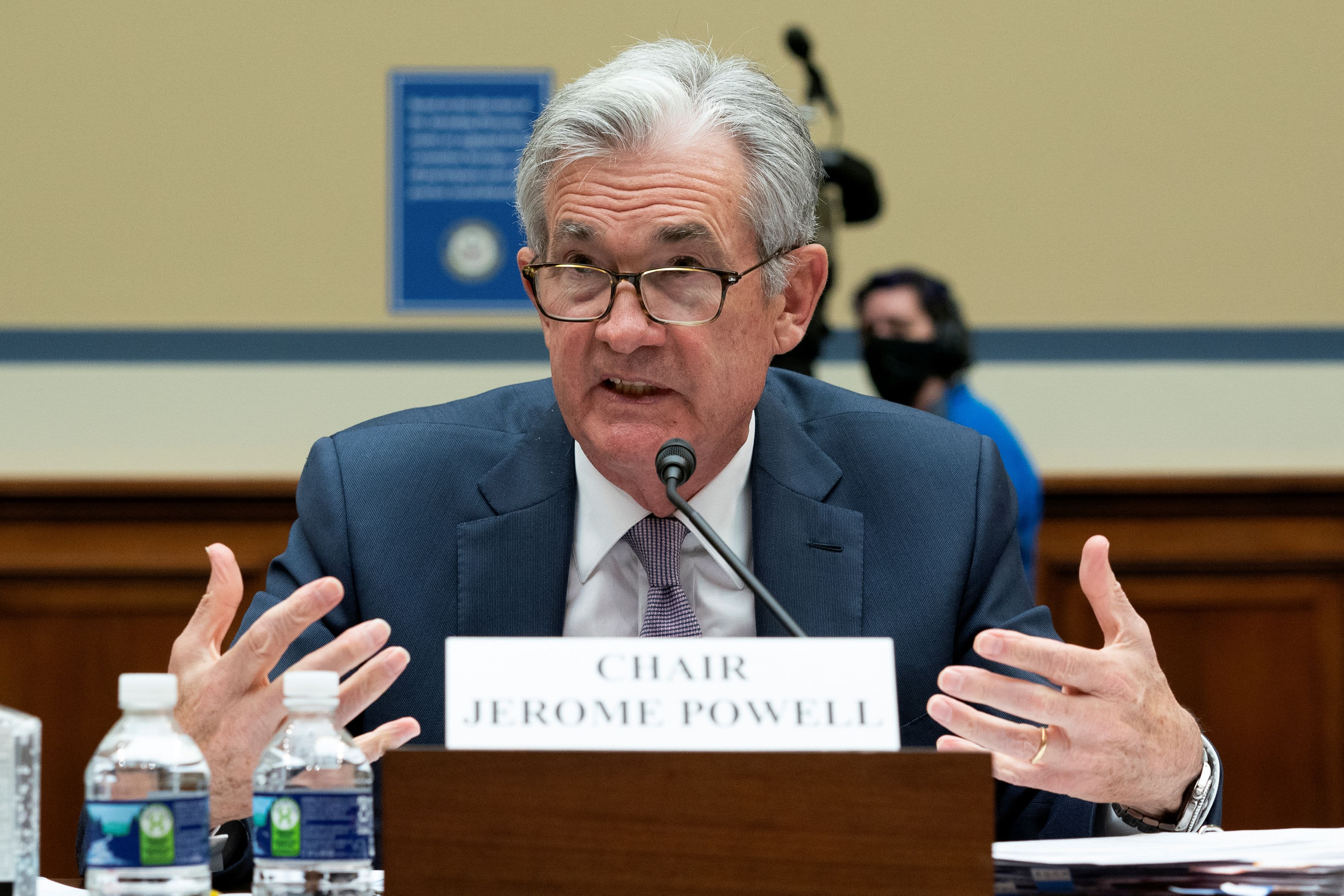 Powell notes economic improvement, but says the pandemic remains a