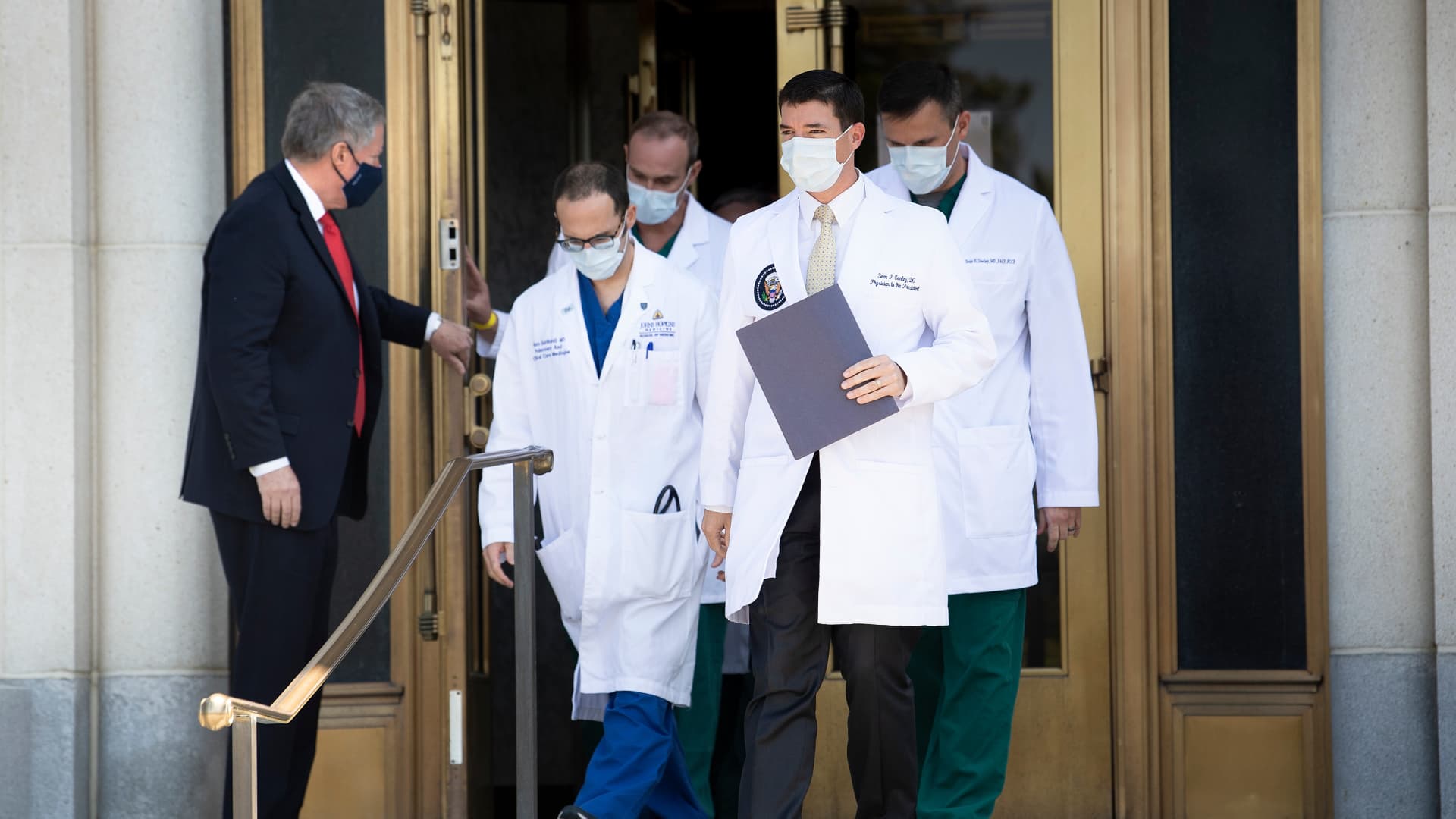 Acting White House Chief of Staff Mark Meadows holds the door for Sean Conley(front C), Physician to US President Donald Trump, and other members of the President's medical team as they arrive to give an update on the President's health at Walter Reed Medical Center during treatment for a COVID-19 infection October 4, 2020, in Bethesda, Maryland.